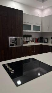 uma cozinha com armários de madeira e uma bancada em Modern cozy apartment em Riyadh