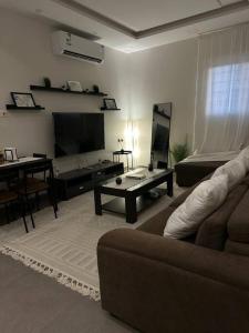 uma sala de estar com um sofá e uma mesa em Modern cozy apartment em Riyadh