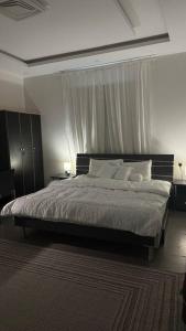 a bedroom with a large bed with white pillows at Modern cozy apartment in Riyadh