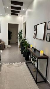 a room with a hallway with a table and plants at Modern cozy apartment in Riyadh