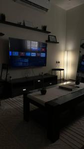 a living room with a large flat screen tv on the wall at Modern cozy apartment in Riyadh