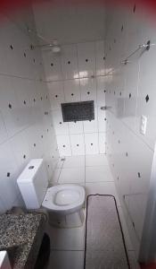 a bathroom with a white toilet in a room at Studio Aconchegante in Palmas