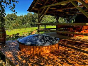 a hot tub on a deck with deer in the background at Domek Klimkówka in Klimkówka