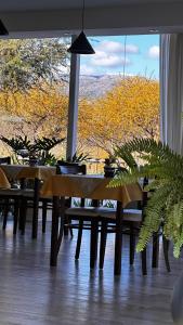 uma sala de jantar com mesas e uma grande janela em Valle Las Piedras em Arroyo de Los Patos