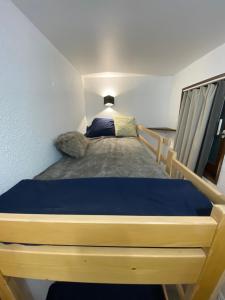 a bedroom with a bed with a blue bedspread at Antarès Location Avoriaz in Avoriaz