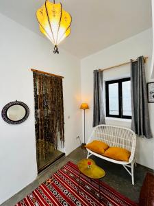 Riad Dar Sebta في الصويرة: غرفة معيشة مع كرسي أبيض ومرآة
