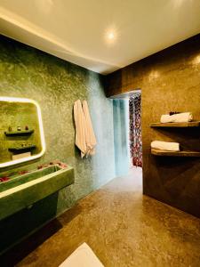 a bathroom with a green sink and a shower at Riad Dar Sebta in Essaouira