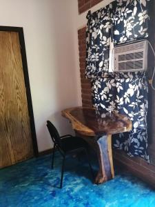 Zimmer mit einem Tisch, einem Stuhl und einem Ventilator in der Unterkunft HOTEL AVE FENIX in Mazunte