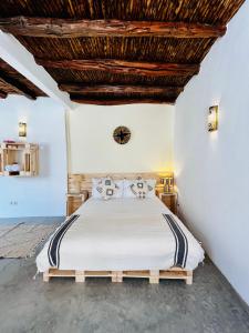 Schlafzimmer mit einem Bett mit Holzdecke in der Unterkunft Riad Dar Sebta in Essaouira