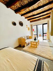 a bedroom with a bed and a living room at Riad Dar Sebta in Essaouira