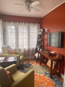 a living room with a couch and a tv at Cozy Cape Cod in Grand Rapids