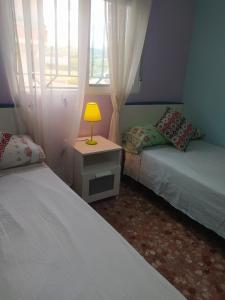 2 Betten in einem Zimmer mit Fenster und Lampe in der Unterkunft Cal surdo in Bolbaite