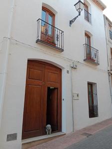 a white building with a wooden door and a fire hydrant at La Milotxa in Adsubia