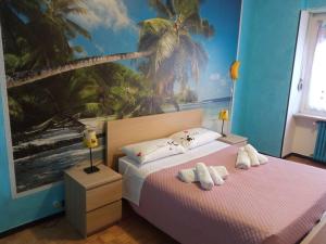 - une chambre avec 2 lits et une fresque murale de palmiers dans l'établissement La casa di Anna, à Collegno
