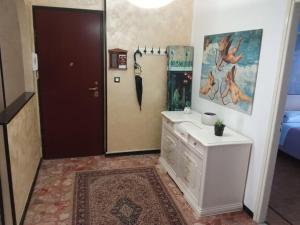 La salle de bains est pourvue d'une commode blanche et d'un miroir. dans l'établissement La casa di Anna, à Collegno