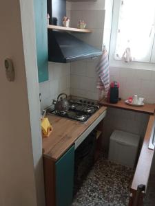 a small kitchen with a stove and a sink at La casa di Anna in Collegno