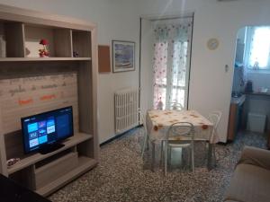 a living room with a table and a television at La casa di Anna in Collegno