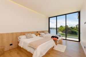 2 camas en una habitación con ventana grande en Espectacular Villa en Guatapé con jacuzzi en frente de la represa, en El Peñol