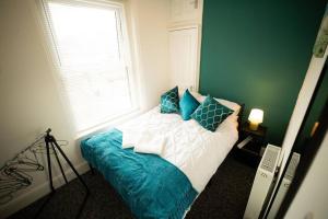 a bedroom with a bed with pillows and a window at Spacious Sea-View Flat w SmartTV in Lowestoft