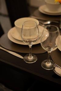 a table with two wine glasses and plates on it at Spacious Sea-View Flat with Easy Invest in Lowestoft