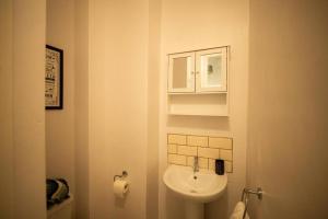 a white bathroom with a sink and a cabinet at Spacious Sea-View Flat with Easy Invest in Lowestoft +45 photos