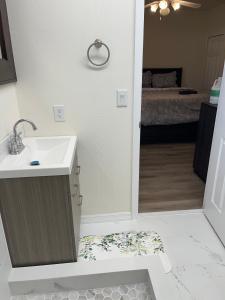 a bathroom with a sink and a room with a bed at ZenHomes in Brandon near Tampa Valrico Seffner in Brandon