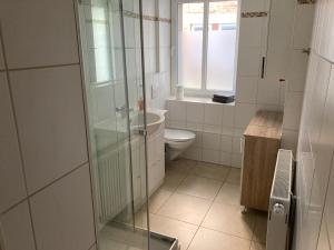 ein Badezimmer mit Toilette und Glasdusche in der Unterkunft Ferienwohnung Funke D5 für Monteure in Apolda