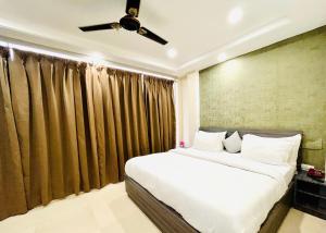 a bedroom with a bed and a ceiling fan at Heaven Hotel in Bareilly
