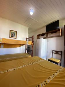 een kamer met 2 stapelbedden en een koelkast bij Pousada Aventura in Passo de Torres