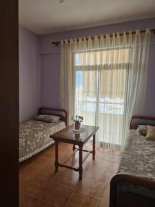een kamer met 2 bedden, een tafel en een raam bij Homemaker in Berat