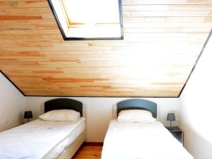 two beds in a small room with wooden walls at Артур in Berdychiv