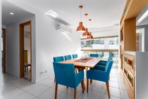a dining room with a table and blue chairs at 4 quartos Linda cobertura no Centro de Itaipava in Bom Sucesso