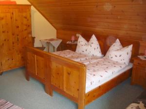 a bedroom with a wooden bed with white pillows at Ferienwohnung Boahof in Lessach