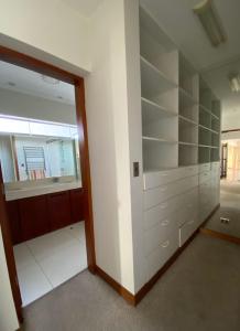 Apartamento Vista al Mar في ليما: غرفة بها رفوف بيضاء ومرآة