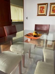 a dining room with a glass table and a chair at Apartamento Vista al Mar in Lima
