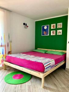 a bed in a room with two green and pink mats at La casita in Civitavecchia