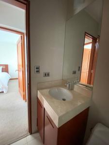 a bathroom with a sink and a large mirror at Apartamento Vista al Mar in Lima