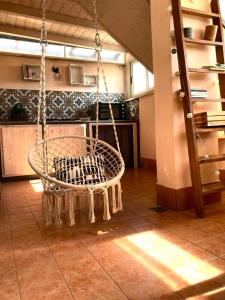 a swinging chair in a room with a kitchen at La casita in Civitavecchia