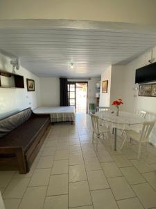a room with a bed and a table and chairs at Pousada Aventura in Passo de Torres