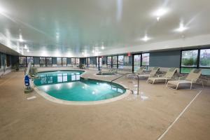 een groot zwembad in een groot gebouw met stoelen bij Wingate by Wyndham Waynesboro in Waynesboro