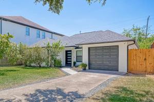a house with a garage and a fence at Stylish, 2 Bedroom in Houston-Bellaire in Houston