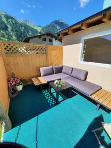 eine Terrasse mit einem Sofa und einem Tisch auf dem Balkon in der Unterkunft Ferienwohnung Hilber in Schmirn