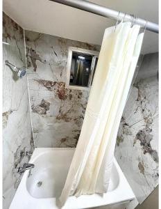 een badkamer met een wit douchegordijn en een bad bij Super 8 by Wyndham Blythe in Blythe