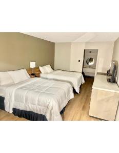 a hotel room with two beds and a television at Super 8 by Wyndham Blythe in Blythe