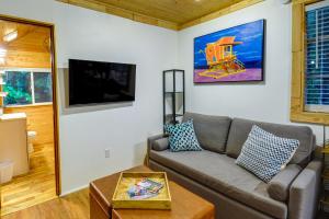 uma sala de estar com um sofá e uma televisão em Adorable A-Frame Cabin, Steps to Lake Cushman! em Hoodsport