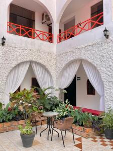 einen Innenhof mit einem Tisch, Stühlen und Pflanzen in der Unterkunft Hotel Firenze in Tarapoto