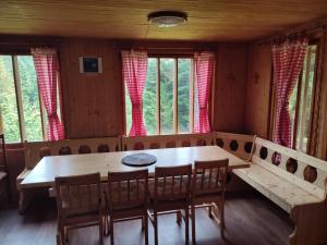 Chata FORESTINA في حمامات فيشنا روجباخي: غرفة طعام مع طاولة وكراسي ونوافذ