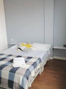 - un lit avec une couverture en damier bleu et blanc dans l'établissement Apartamento en Pereira sobre la avenida principal de la ciudad 203, à Pereira