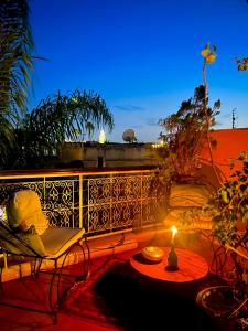 un patio con tavolo e una candela sul balcone di Riad Alamine a Marrakech