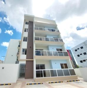 um edifício branco alto com janelas em Chelsie 3 vista piscina em Bayahibe